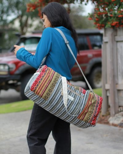 Colorful Vibrant large duffle bag carrying by a woman on her side outdoor setting