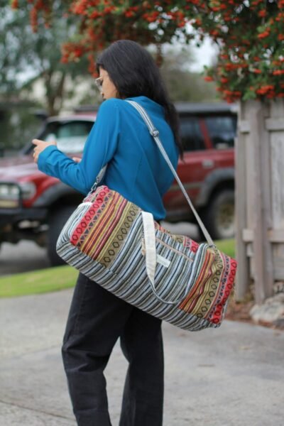 Colorful Vibrant large duffle bag carrying by a woman on her side outdoor setting