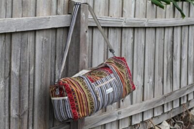 Colorful Vibrant Duffle Bag hanging on the fence