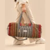 a woman carrying colorful and vibrant duffle bag by its handle
