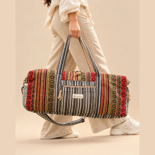 a woman carrying colorful and vibrant duffle bag by its handle