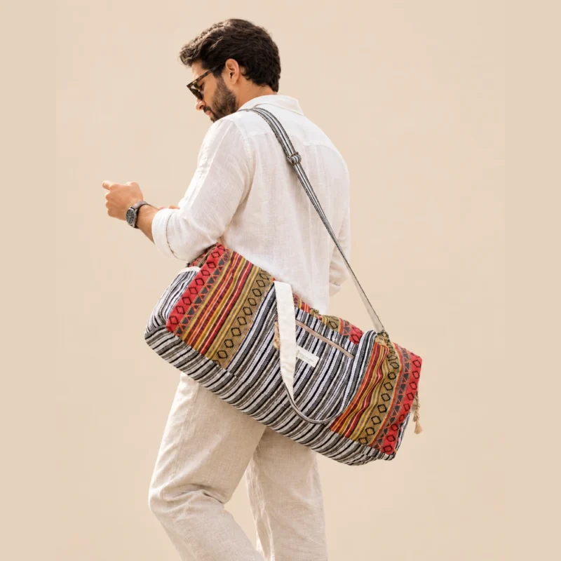 a man carrying colorful and vibrant duffle bag and looking at his phone