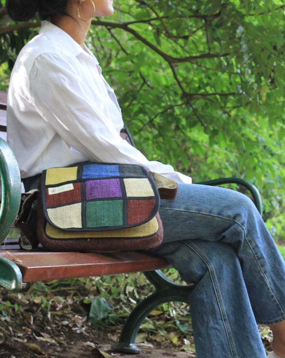 a person sitting with vibrant hemp bag on a bench at a park