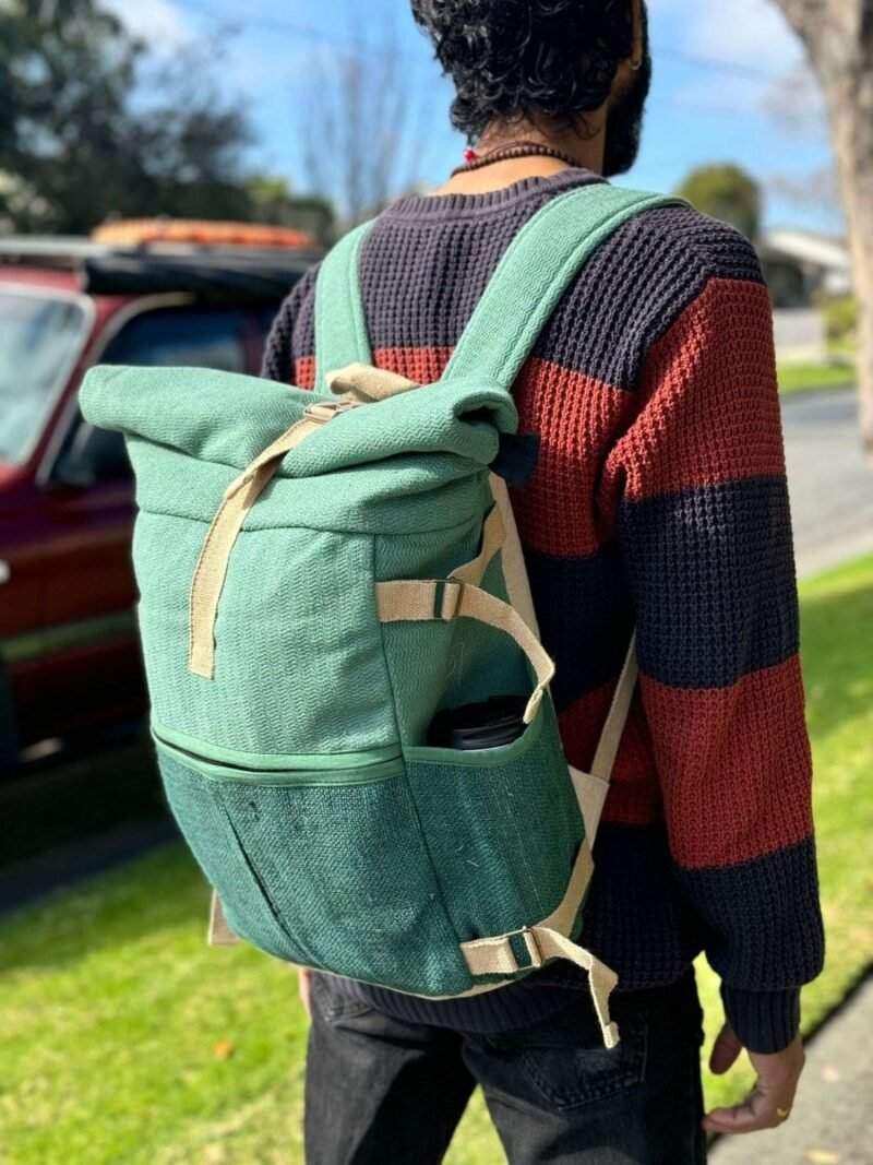 man carrying green roll top large hemp backpack
