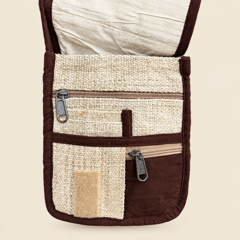 Hemp crossbody bag with the flap lifted to show zip pockets and hook and loop closure