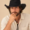 Male model wearing Black KTM Safari Hat with Chin String, featuring a wide shapable brim, woven Himalayan hemp texture and adjustable black chin cord.