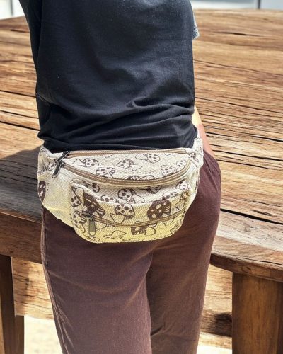 women carrying mushroom printed beige bum bag on hip