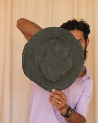 A man holding green solid hemp hat