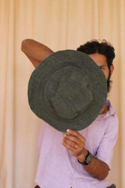 A man holding green solid hemp hat