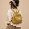 a woman carrying mustard mini hemp backpack