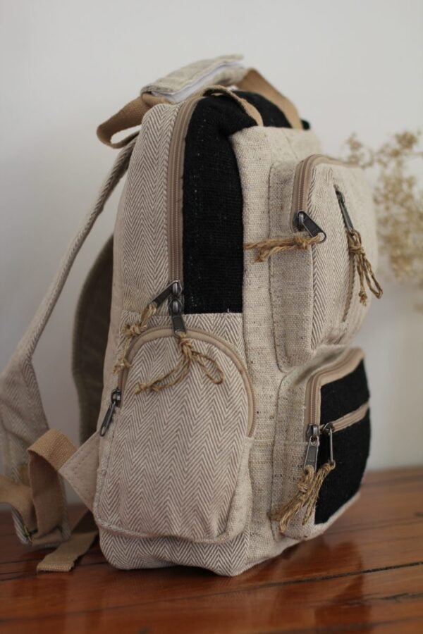 Handmade hemp maternity backpack displayed on a wooden table indoors Side view