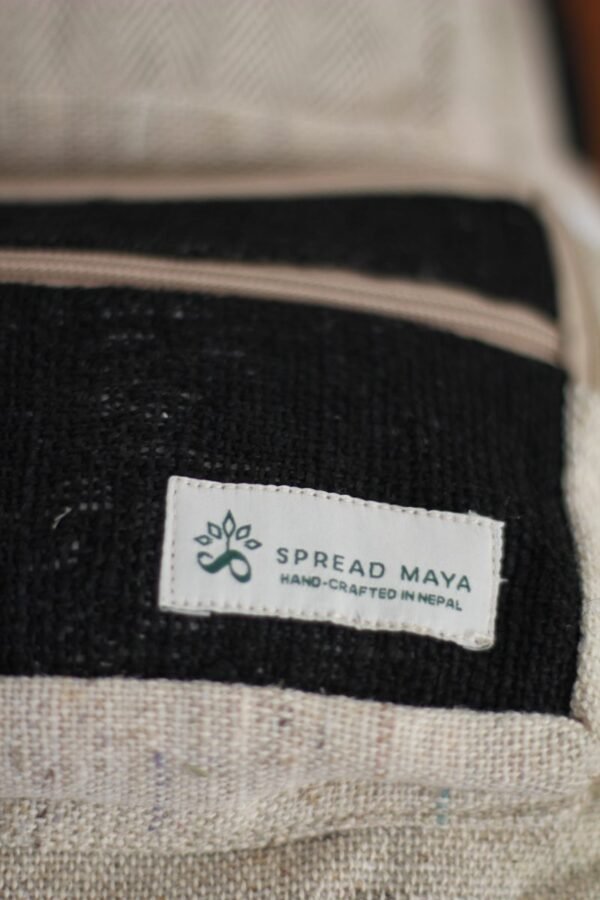 Handmade hemp maternity backpack displayed on a wooden table indoors spreadmaya logo