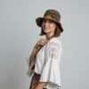 A woman posing in colorful hemp crochet hat in plain background