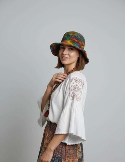A woman posing in colorful hemp crochet hat in plain background