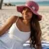 A woman posing at the beach wearing Hemp Crochet Pink Sun hat
