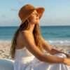 a woman wearing hemp crochet hat by the beach and enjoying the sun