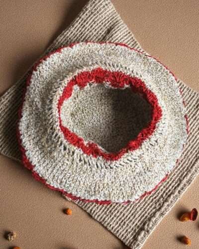 Gurkha looms red crochet hat inside photo on table