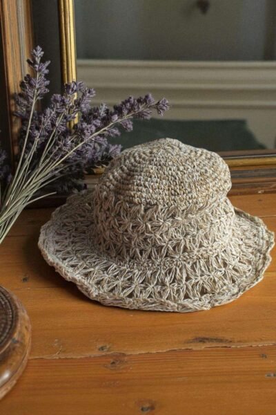Beige Nest Crochet Hat placed on a wooden table