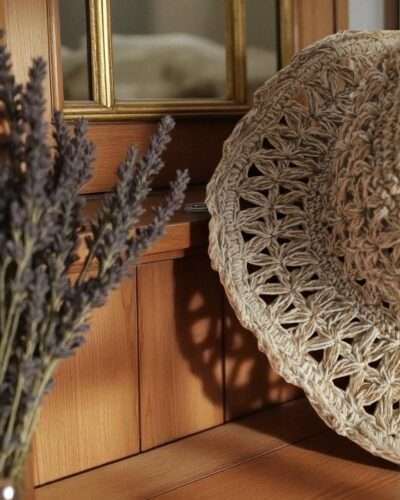 Beige Nest Crochet Hat placed on a wooden table