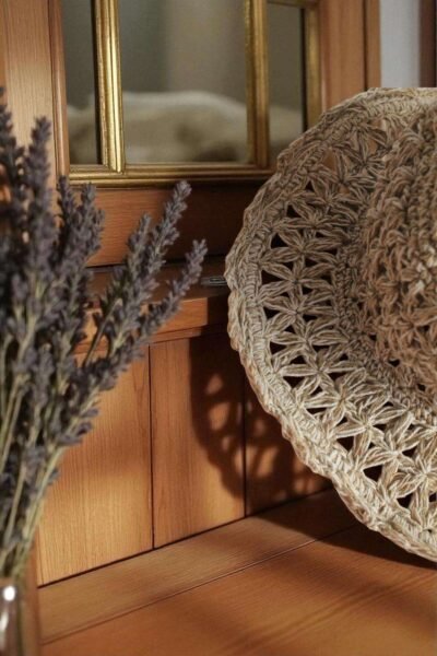 Beige Nest Crochet Hat placed on a wooden table