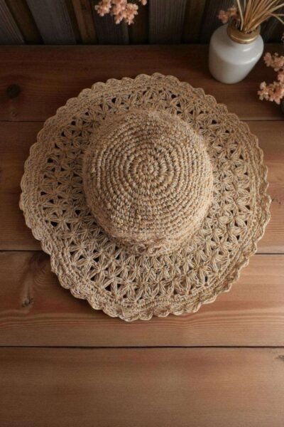 Beige Nest Crochet Hat placed on a wooden table