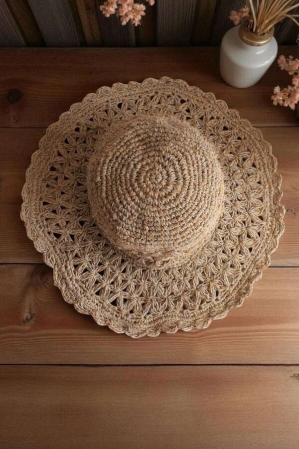 Beige Nest Crochet Hat placed on a wooden table