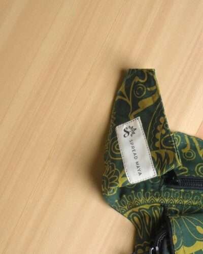 Green Cotton Bum Bag laid flat on a wooden surface