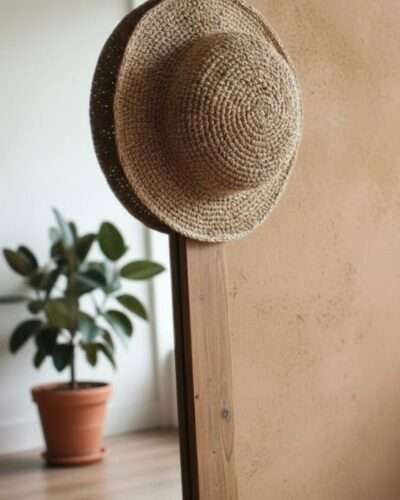 Simple beige crochet hat hanged on a mirror