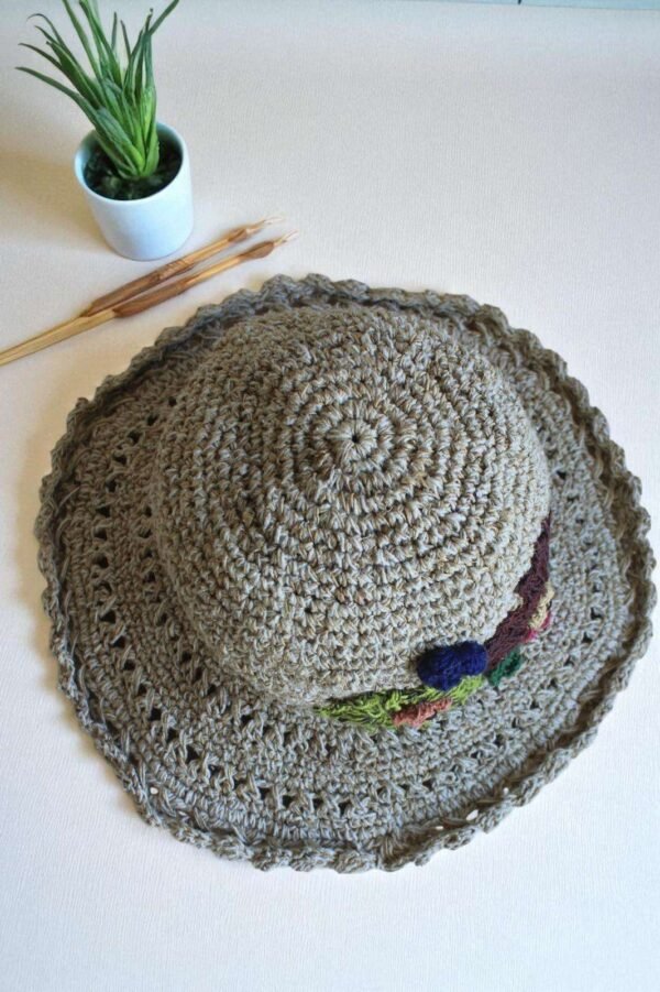hemp crochet hat with flower embroidery placed a table