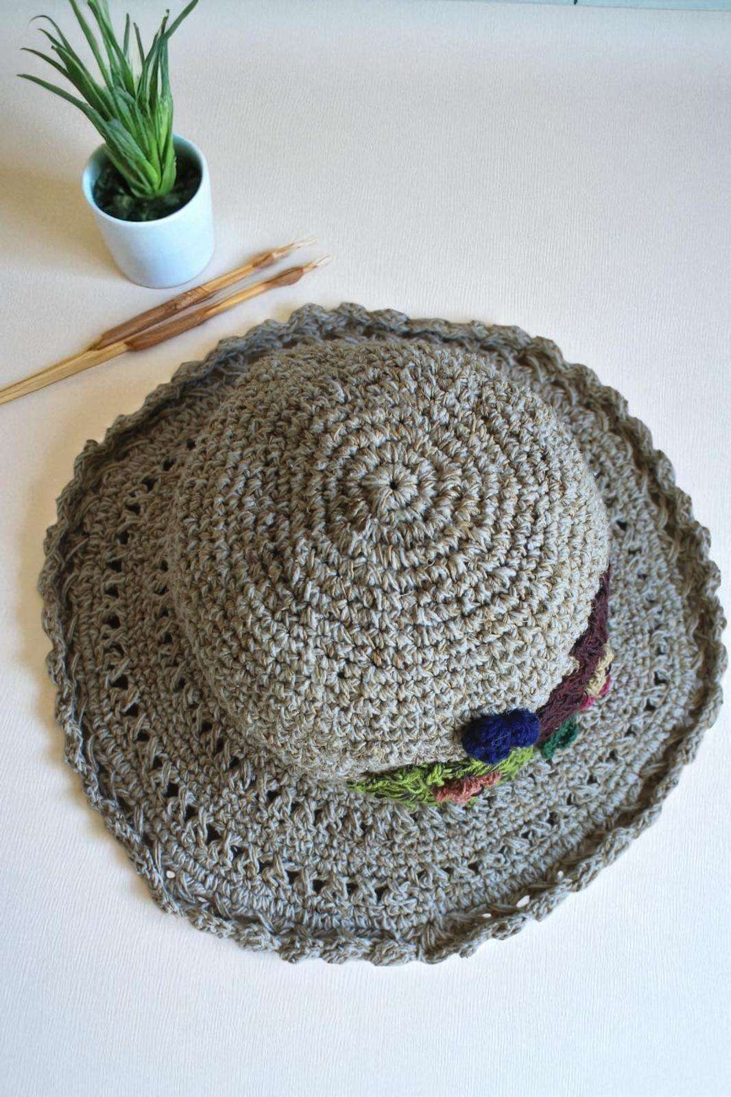 hemp crochet hat with flower embroidery placed a table