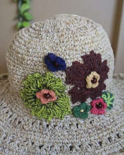 hemp crochet hat with flower embroidery placed a table