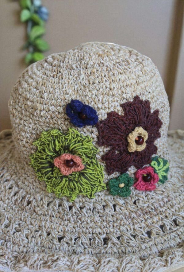 hemp crochet hat with flower embroidery placed a table