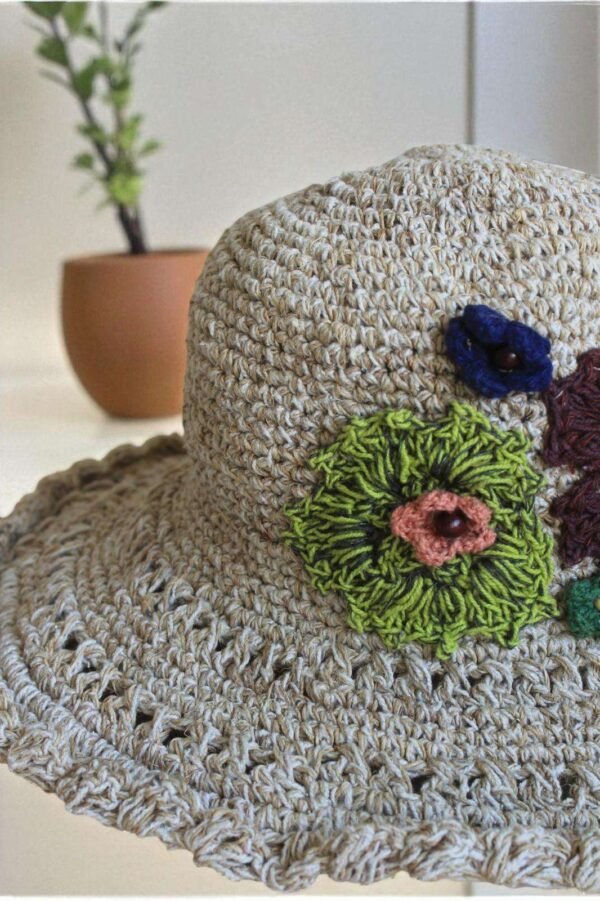 hemp crochet hat with flower embroidery placed a table