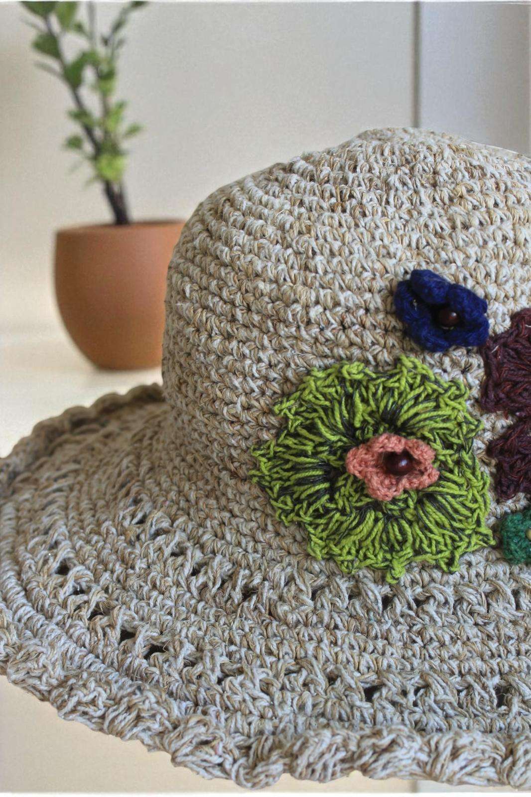 hemp crochet hat with flower embroidery placed a table