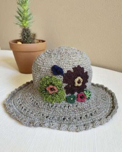 hemp crochet hat with flower embroidery placed a table