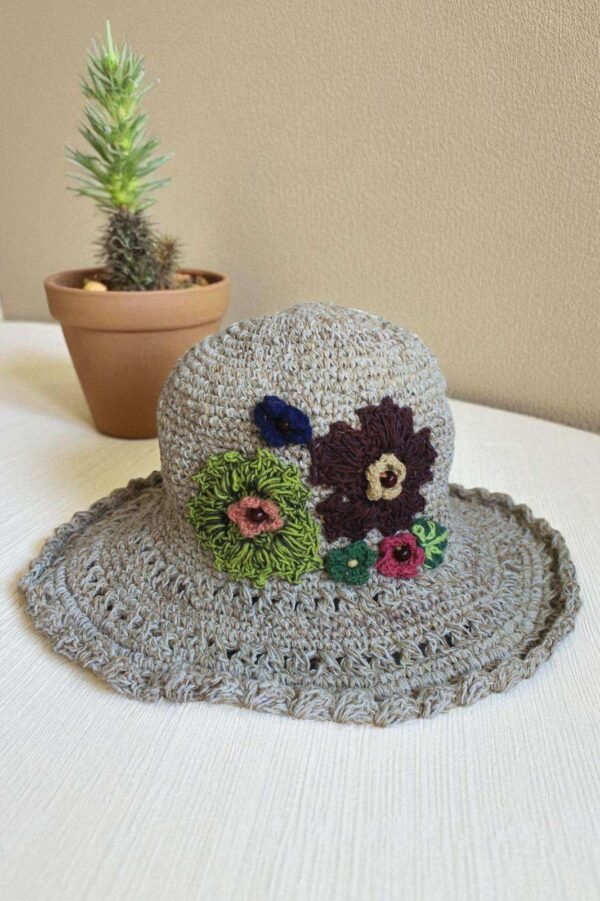 hemp crochet hat with flower embroidery placed a table