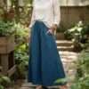 a model wearing teal cotton wide leg trousers in outdoor setting