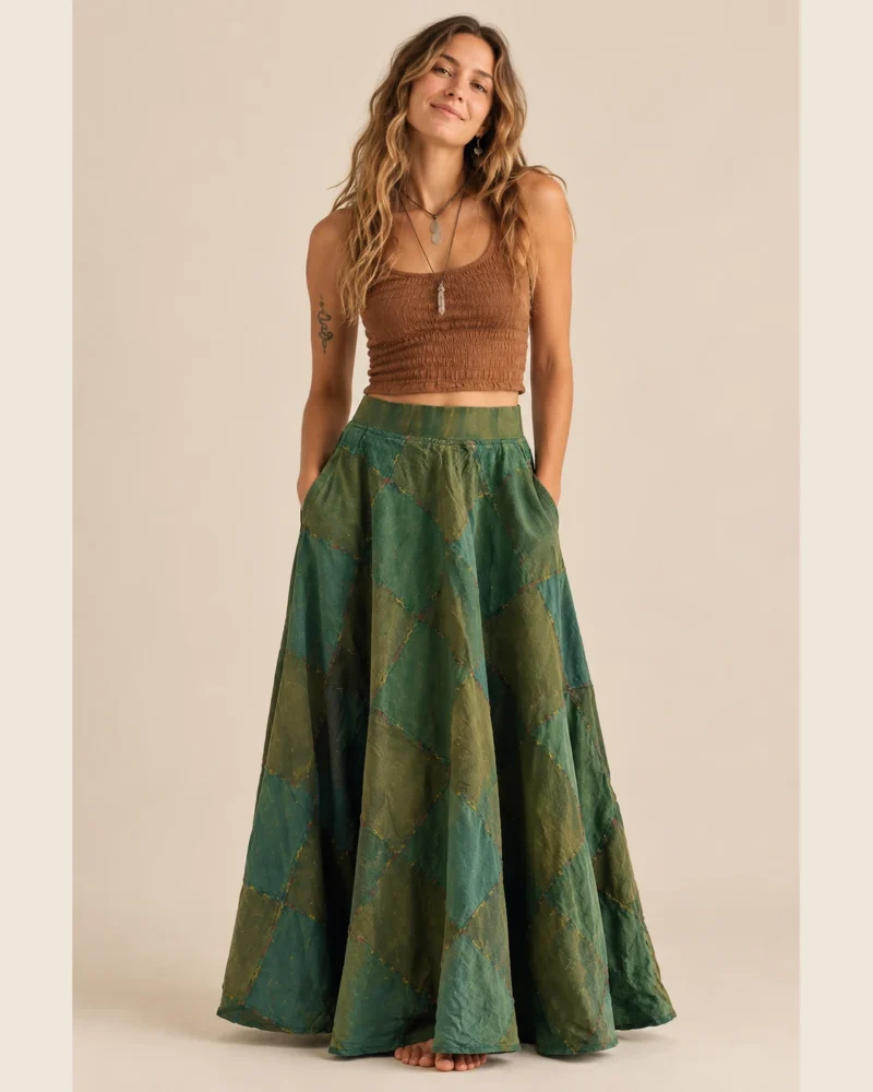 Woman wearing a green patchwork maxi skirt with side pockets and a flowing bohemian design by SpreadMaya.
