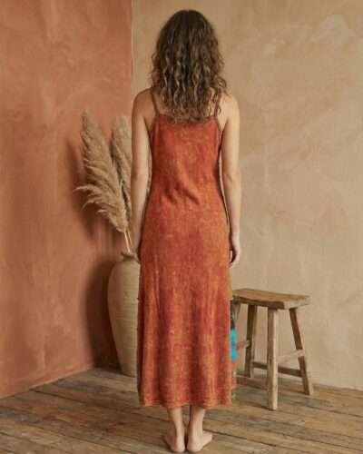 a model wearing retro patchwork dress and posing in earthy background