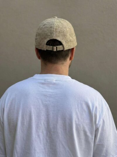 a man wearing beige hemp cap and posing from back