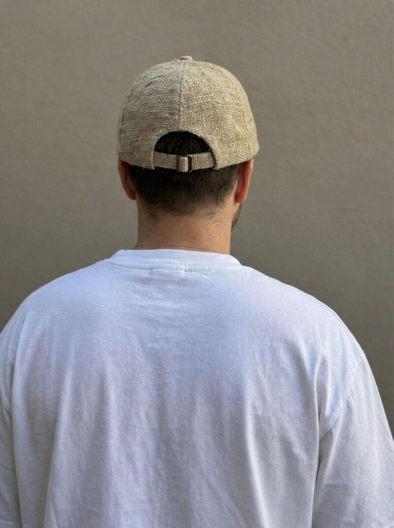a man wearing beige hemp cap and posing from back