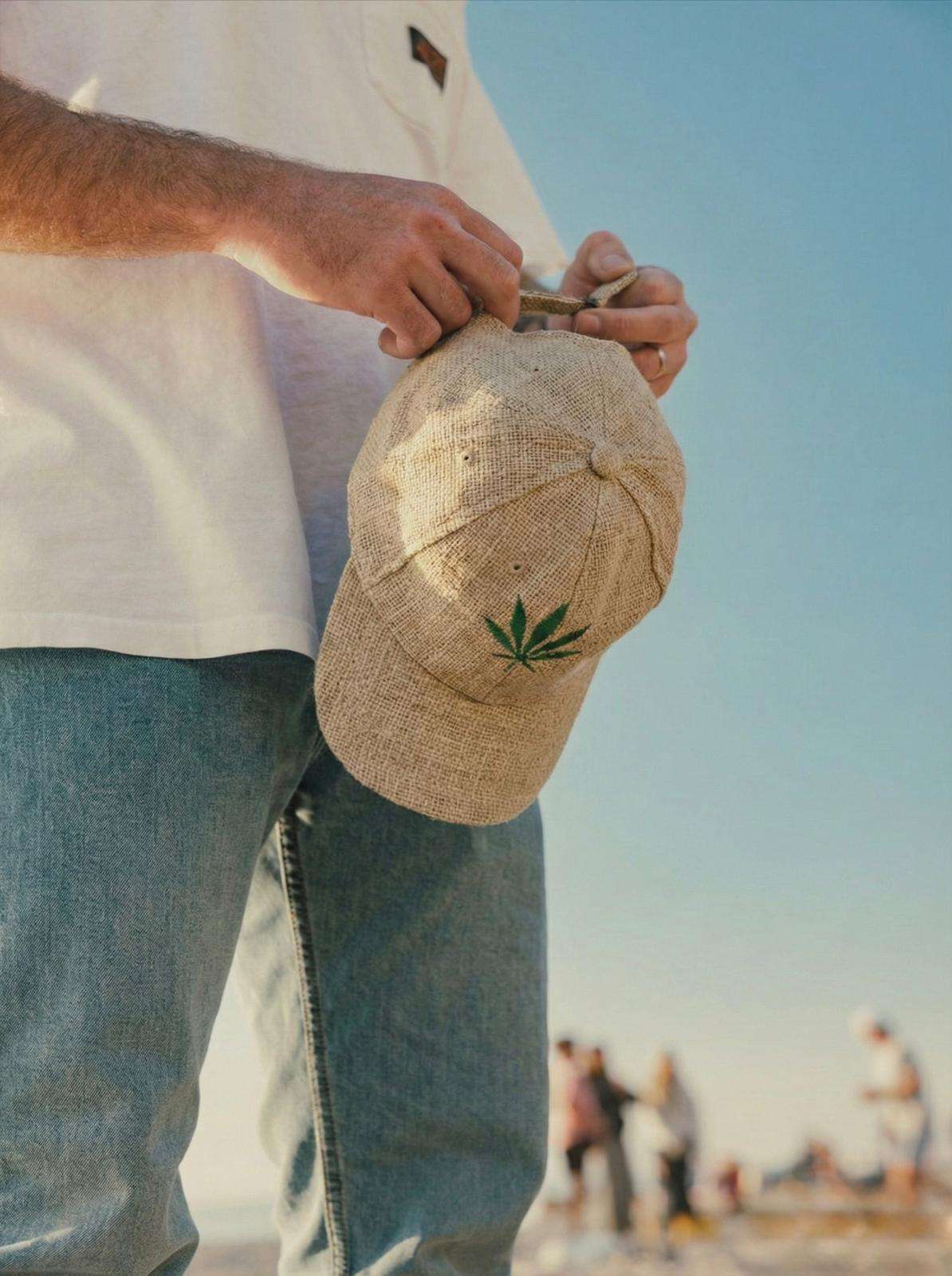 Man adjusting the strap of a beige hemp cap, handmade and breathable