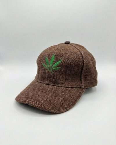 Brown hemp cap with leaf embroidery displayed on a bench