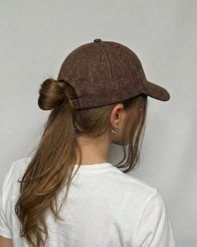 Back view of brown hemp cap showing adjustable strap on woman