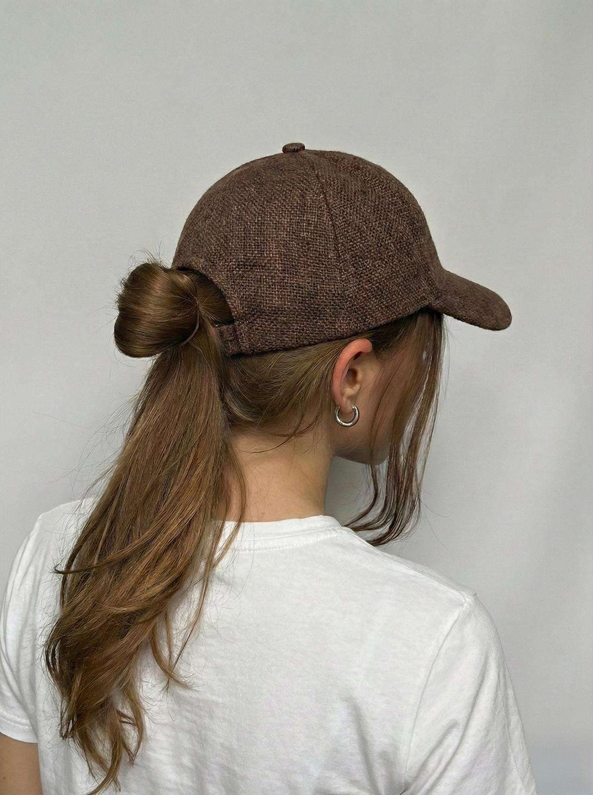 Back view of brown hemp cap showing adjustable strap on woman