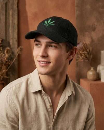 a man posing looking sideways wearing black hemp printed cap