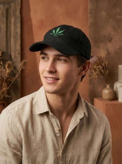a man posing looking sideways wearing black hemp printed cap