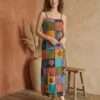 a model wearing retro patchwork dress and posing in earthy background