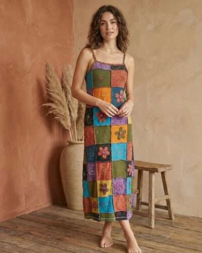 a model wearing retro patchwork dress and posing in earthy background