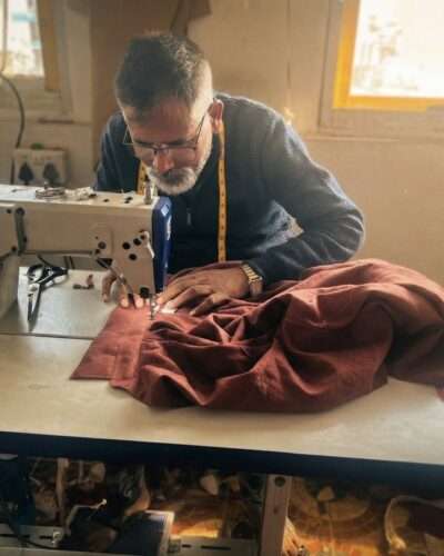 nepali man sewing hemp shirt